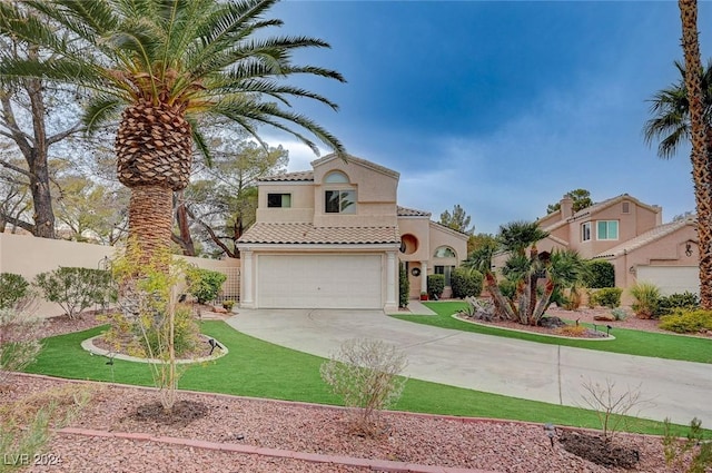 mediterranean / spanish home with a front yard and a garage