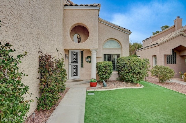 doorway to property with a yard