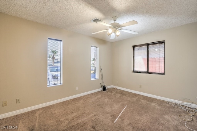 carpeted empty room featuring ceiling fan and a textured ceiling