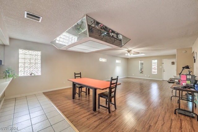 dining room with ceiling fan, wood-type flooring, and a textured ceiling