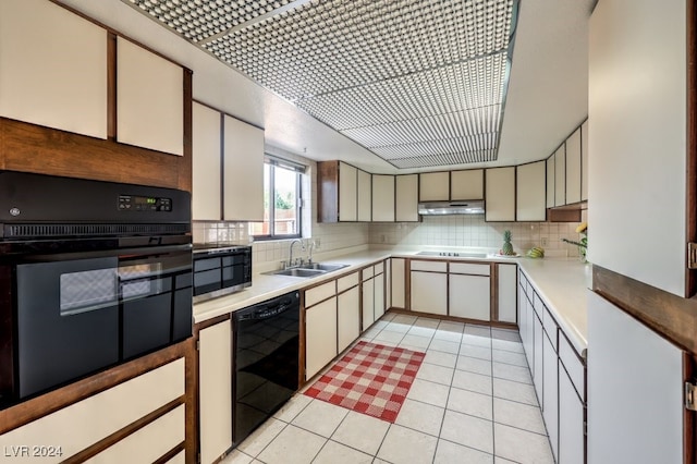 kitchen featuring light tile patterned floors, sink, backsplash, and black appliances