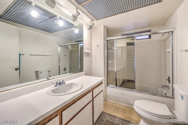 full bathroom featuring shower / bath combination with glass door, tile patterned floors, vanity, and toilet