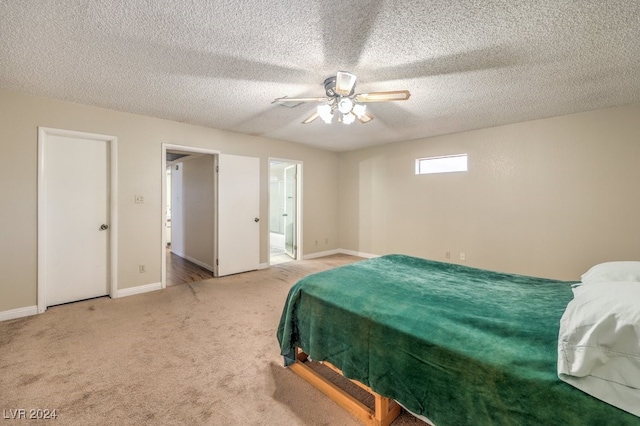 carpeted bedroom with ceiling fan and a textured ceiling