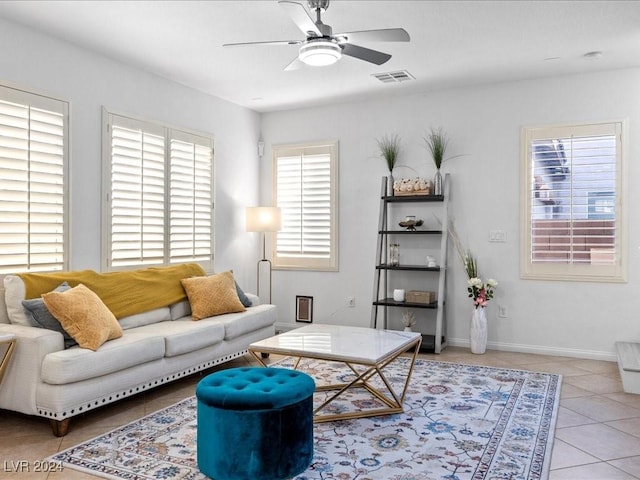 living room featuring light tile patterned floors, visible vents, baseboards, and ceiling fan