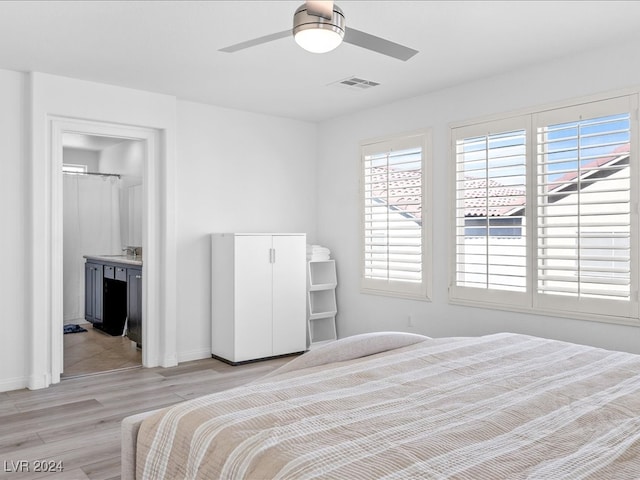 bedroom featuring ceiling fan, light hardwood / wood-style flooring, and ensuite bathroom