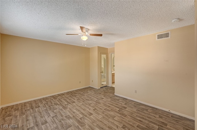 spare room featuring ceiling fan, wood-type flooring, and a textured ceiling