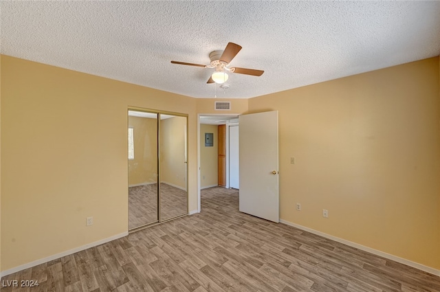 unfurnished bedroom with ceiling fan, a closet, a textured ceiling, and light wood-type flooring