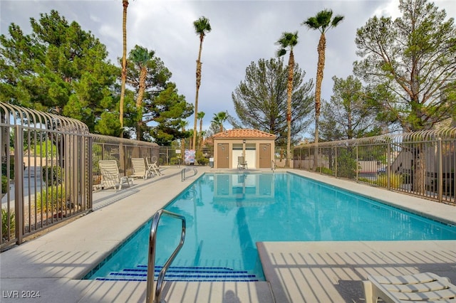 view of pool with a patio area and an outbuilding