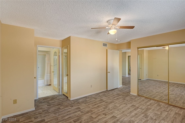 unfurnished bedroom featuring ceiling fan, a closet, a textured ceiling, and light hardwood / wood-style flooring