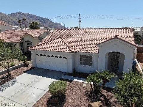 mediterranean / spanish-style house with a mountain view and a garage