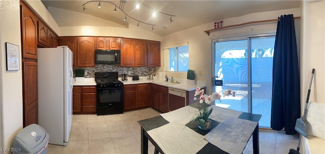 kitchen with black appliances, sink, vaulted ceiling, light tile patterned floors, and tasteful backsplash