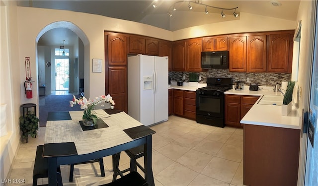 kitchen featuring decorative backsplash, sink, black appliances, light tile patterned floors, and lofted ceiling