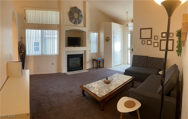 carpeted living room featuring a fireplace and high vaulted ceiling