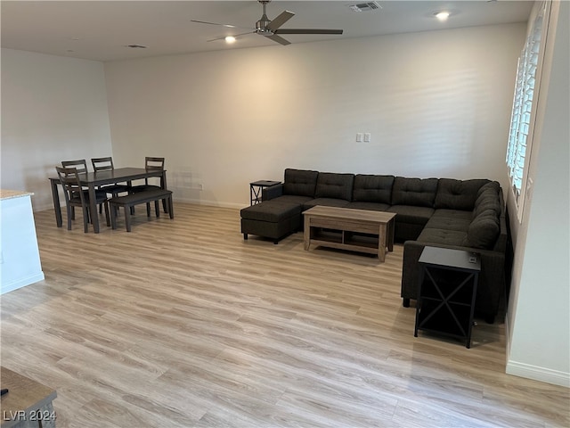 living room with ceiling fan and light hardwood / wood-style flooring