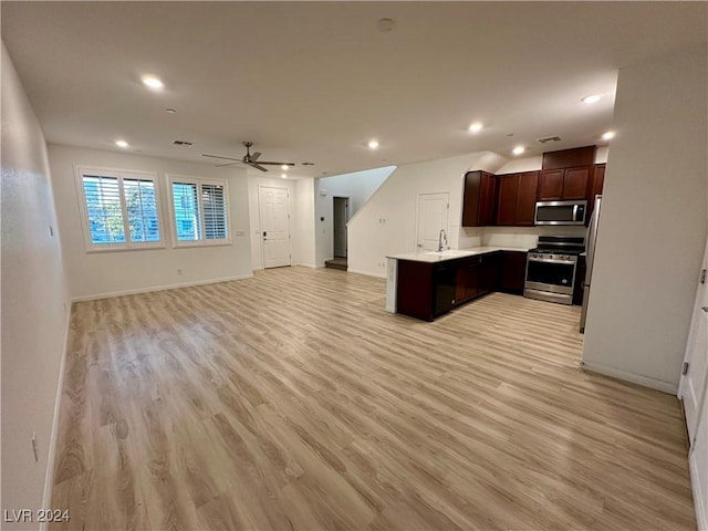 kitchen featuring light wood-style flooring, appliances with stainless steel finishes, open floor plan, and light countertops