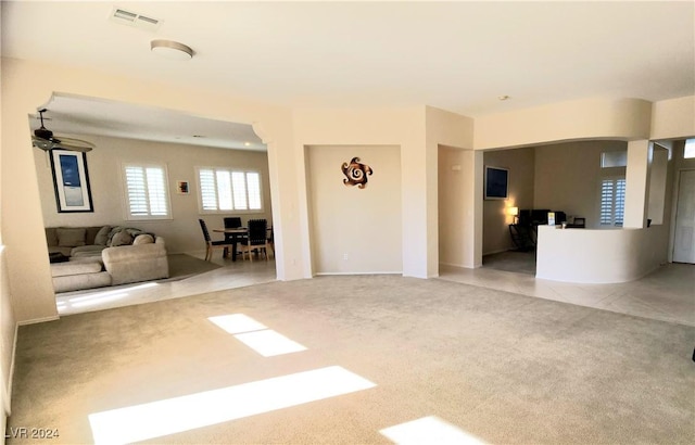 unfurnished living room featuring light colored carpet and ceiling fan