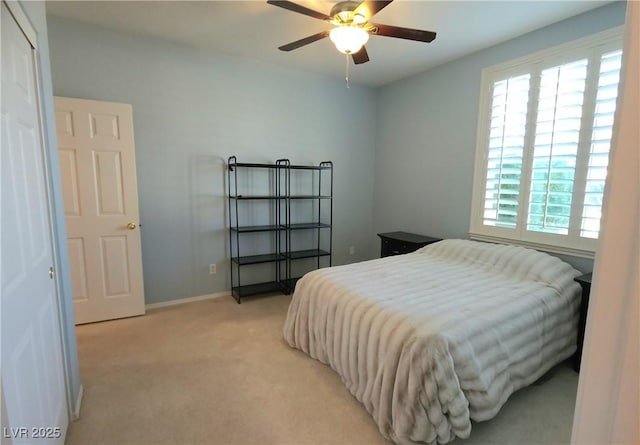 bedroom featuring a ceiling fan, light colored carpet, baseboards, and multiple windows