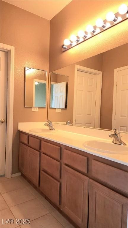 full bathroom featuring double vanity, tile patterned flooring, and a sink