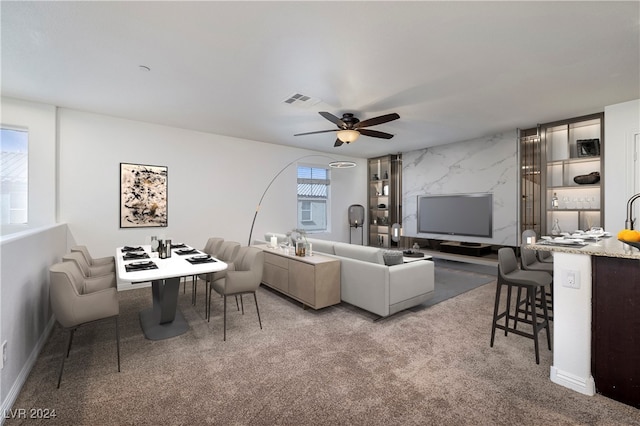 carpeted living room with ceiling fan and a healthy amount of sunlight