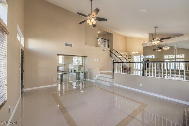 stairway featuring tile patterned floors, high vaulted ceiling, and a notable chandelier