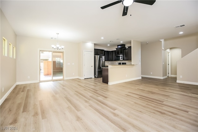 unfurnished living room featuring ceiling fan with notable chandelier and light wood-type flooring