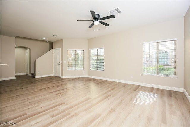 unfurnished room featuring light wood-type flooring, a wealth of natural light, and ceiling fan