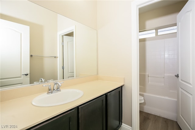 full bathroom with wood-type flooring, vanity, shower / bath combination, and toilet