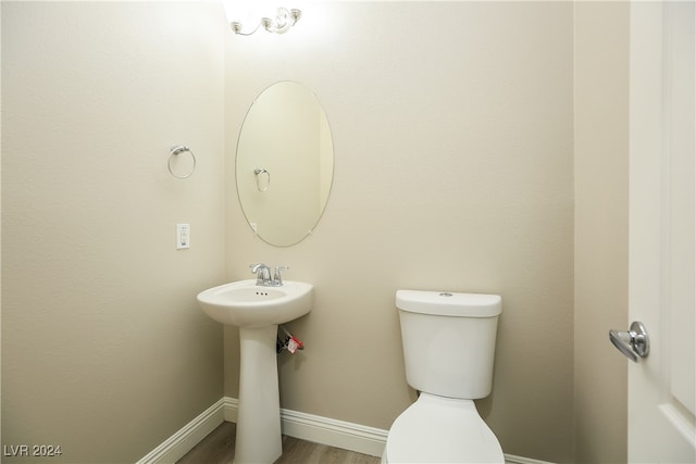 bathroom with hardwood / wood-style flooring and toilet