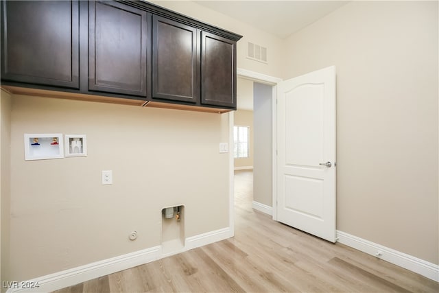 washroom with cabinets, hookup for a washing machine, light hardwood / wood-style floors, and hookup for a gas dryer