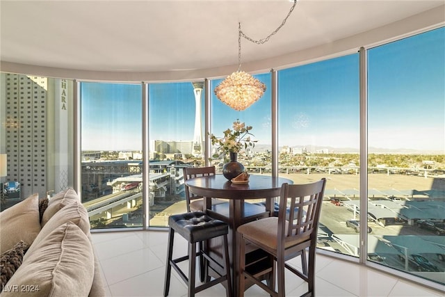 sunroom / solarium featuring an inviting chandelier and a city view