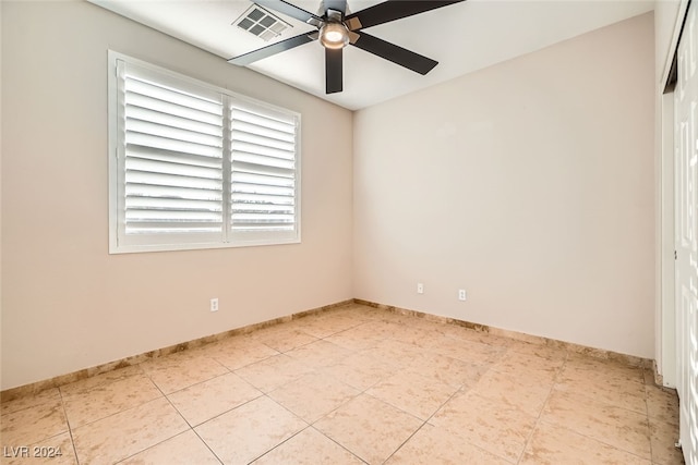 tiled empty room featuring ceiling fan