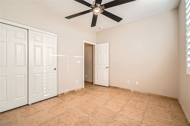 unfurnished bedroom with ceiling fan and a closet