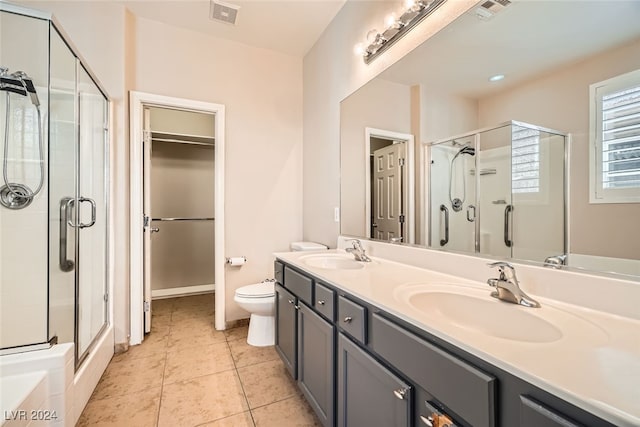 bathroom featuring tile patterned floors, toilet, vanity, and walk in shower