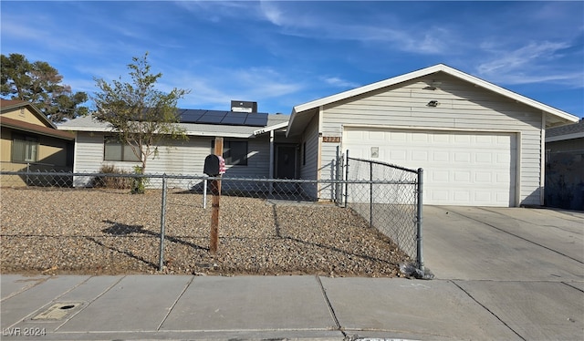 ranch-style home featuring a garage and solar panels