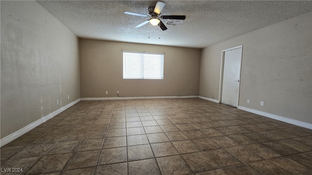 tiled spare room with a textured ceiling and ceiling fan