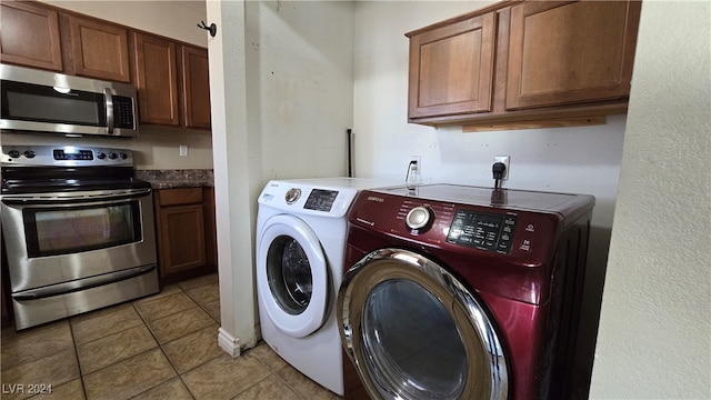 washroom featuring washing machine and dryer and light tile patterned floors