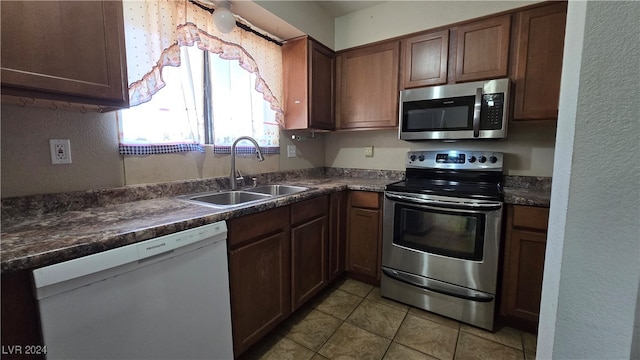 kitchen with sink, light tile patterned floors, and appliances with stainless steel finishes