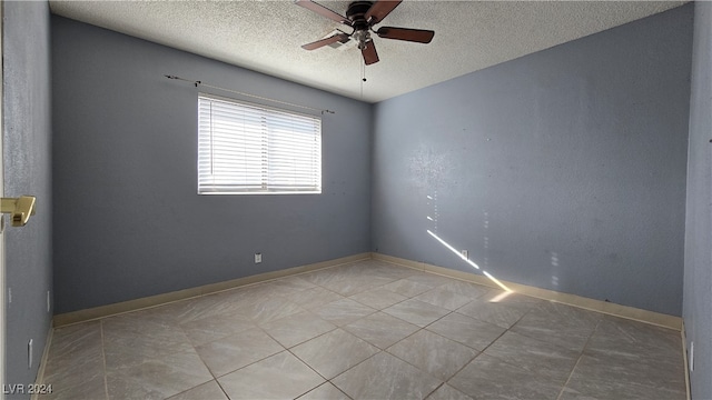 tiled empty room with ceiling fan and a textured ceiling