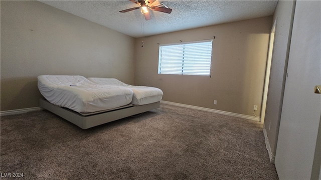 bedroom featuring a textured ceiling, dark carpet, and ceiling fan