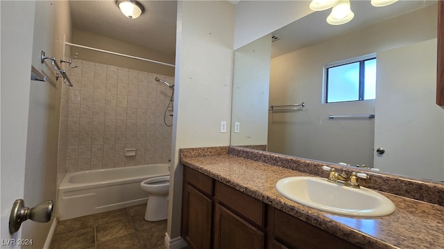 full bathroom with tile patterned floors, vanity, tiled shower / bath combo, and toilet