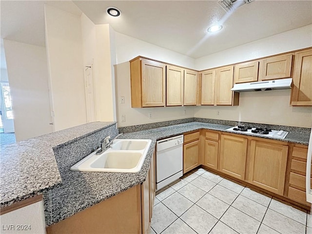 kitchen featuring light tile patterned floors, light brown cabinets, under cabinet range hood, white appliances, and a sink