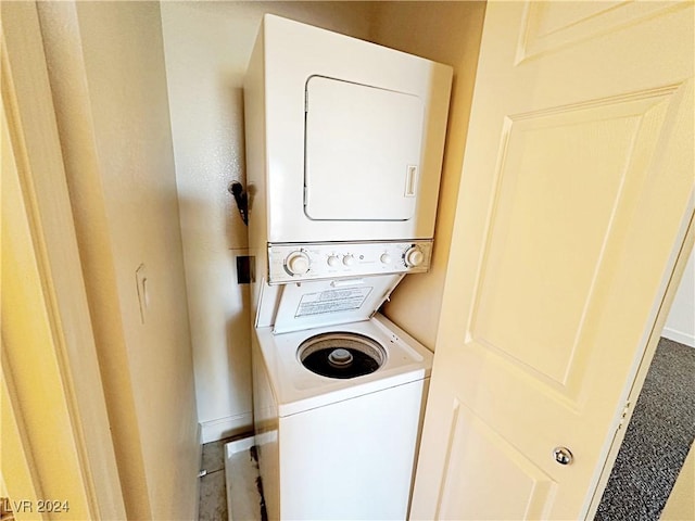 clothes washing area with stacked washing maching and dryer and laundry area