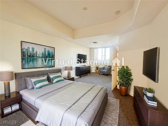 bedroom featuring a tray ceiling, carpet flooring, visible vents, and baseboards