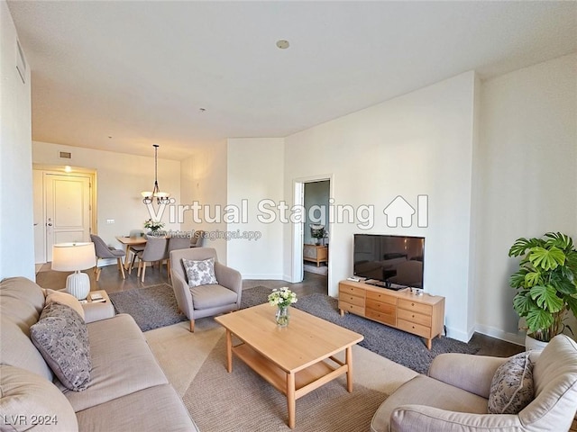 living area featuring visible vents, a notable chandelier, and baseboards