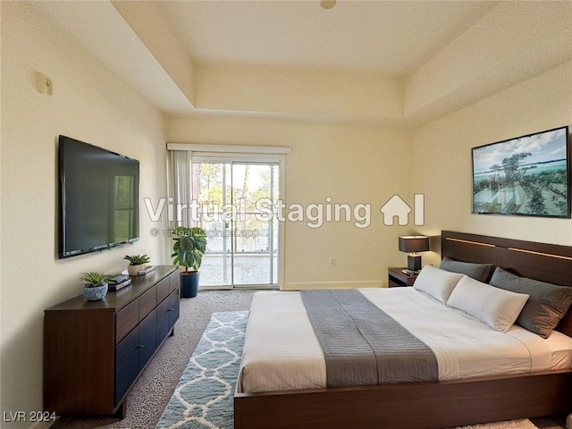 bedroom featuring access to outside, carpet flooring, and a tray ceiling