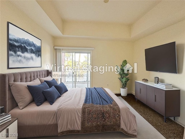 bedroom featuring access to exterior, a raised ceiling, carpet flooring, and baseboards