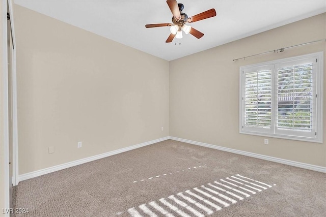 carpeted spare room with baseboards and ceiling fan
