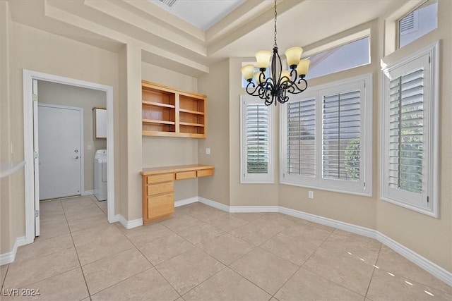 unfurnished dining area with light tile patterned floors, washer / clothes dryer, a chandelier, built in desk, and baseboards
