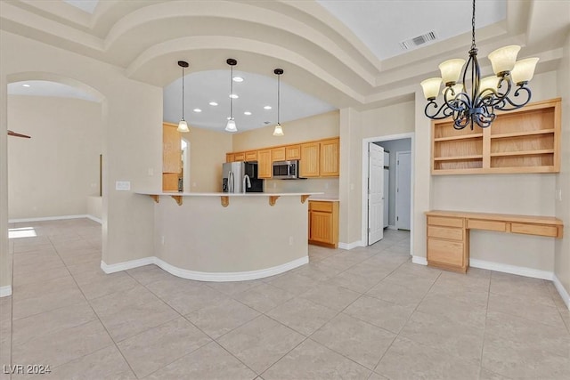kitchen with a breakfast bar, a chandelier, a peninsula, light countertops, and appliances with stainless steel finishes