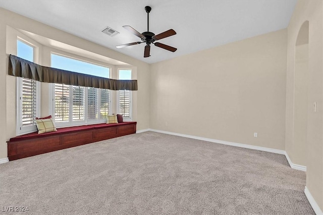 spare room with visible vents, ceiling fan, carpet, and baseboards